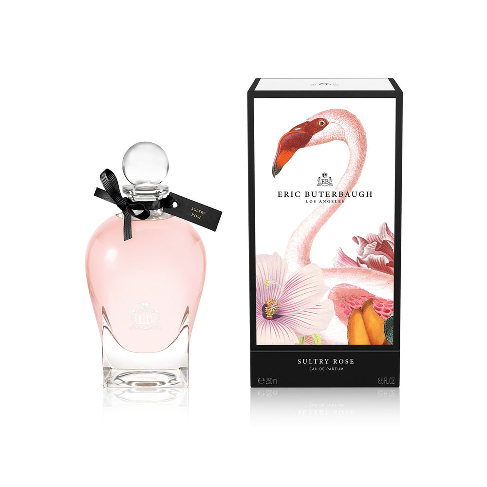 250 ml bottle, with transparent glass and pinkish perfum. Spherical cap with black ribbon. By his side the box, with pink flamingo and flowers illustration, within a black border. Sultry Rose, a fragrance by Eric Butherbaugh.