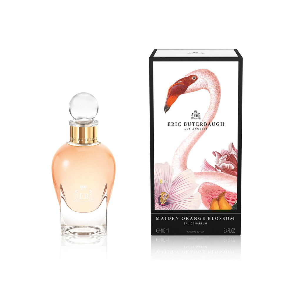 100 ml bottle, with transparent glass and orangey perfum. Spherical cap with gold band. By his side the box, with pink flamingo and flowers illustration, within a black border. Maiden Orange Blossom, a fragrance by Eric Butherbaugh.