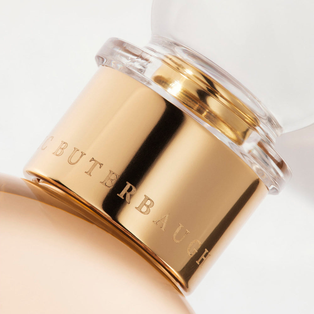 Detail of the top of the 100 ml bottle, with transparent glass and orangey perfum. Spherical cap with gold band. Regal Tuberose, a fragrance by Eric Butherbaugh.