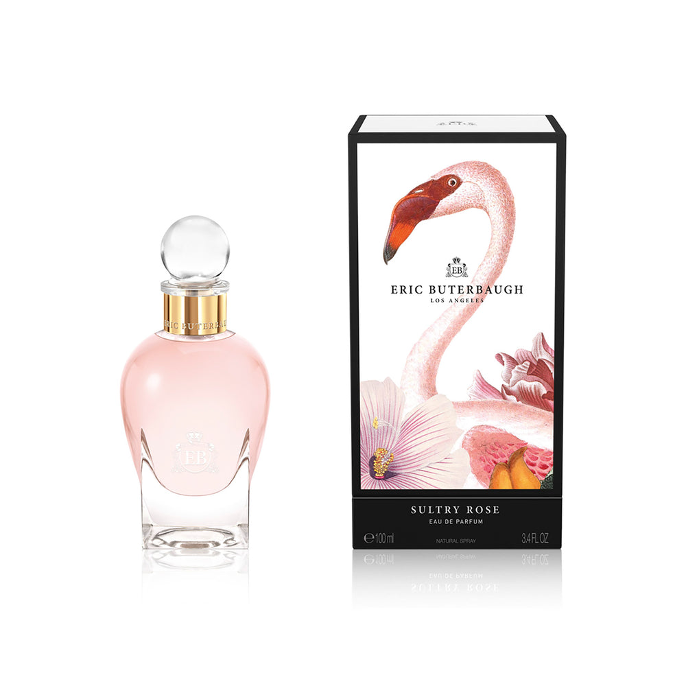 100 ml bottle, with transparent glass and pinkish perfum. Spherical cap with gold band. By his side the box, with pink flamingo and flowers illustration, within a black border. Sultry Rose, a fragrance by Eric Butherbaugh.