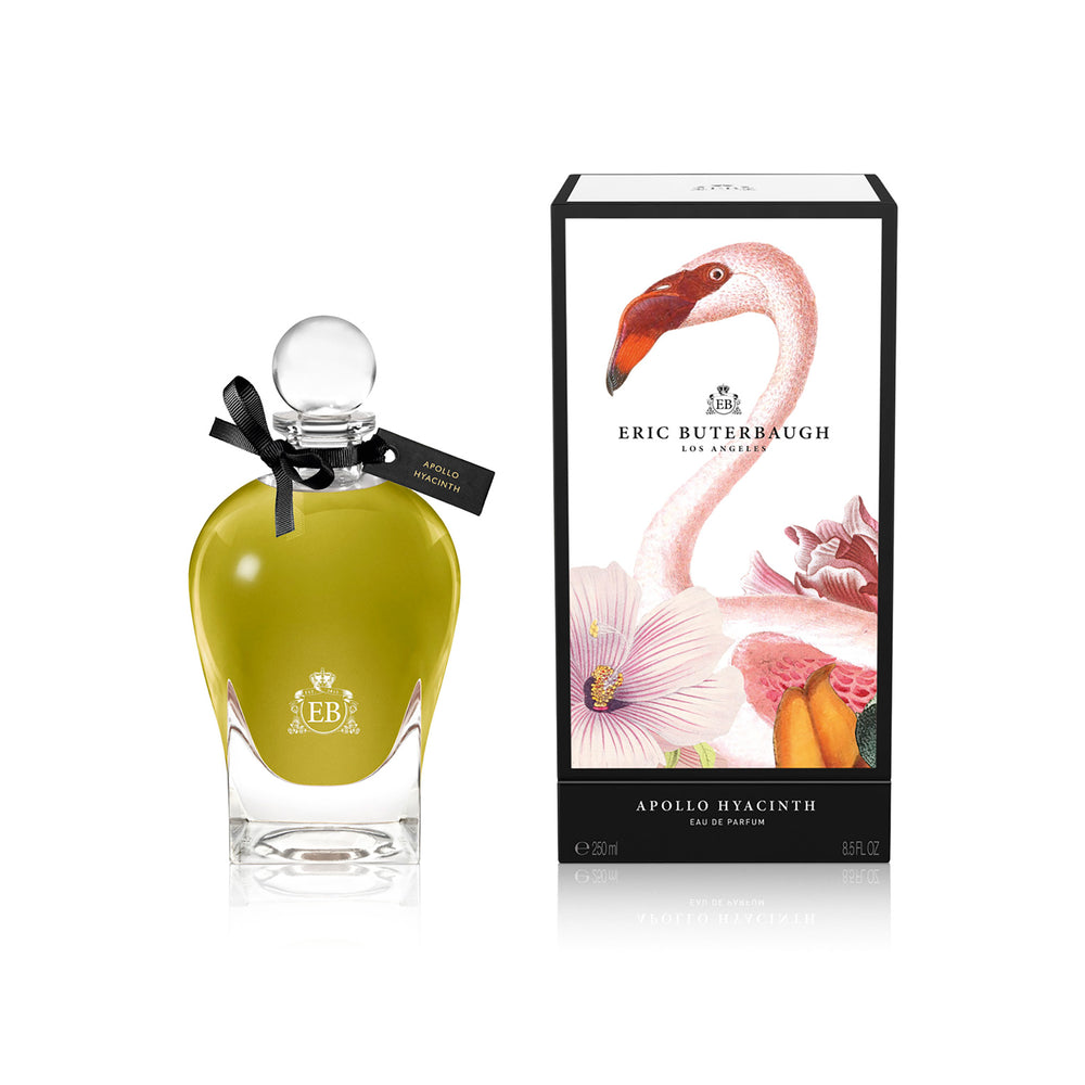 250 ml bottle, with transparent glass and greenish perfum. Spherical cap with black ribbon. By his side the box, with pink flamingo and flowers illustration, within a black border. Apollo Hyacinth, a fragrance by Eric Butherbaugh.