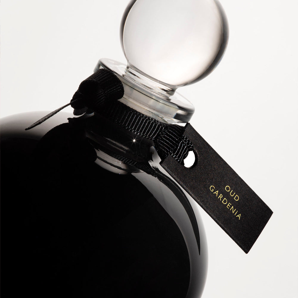 Detail of the top of the 250 ml bottle, with black opaque glass. Spherical cap with black ribbon. Oud Gardenia, a fragrance by Eric Butherbaugh.