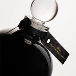 Detail of the top of the 250 ml bottle, with black opaque glass. Spherical cap with black ribbon. Oud Lily of the Valley, a fragrance by Eric Butherbaugh.