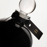 Detail of the top of the 250 ml bottle, with black opaque glass. Spherical cap with black ribbon. Oud Rose, a fragrance by Eric Butherbaugh.