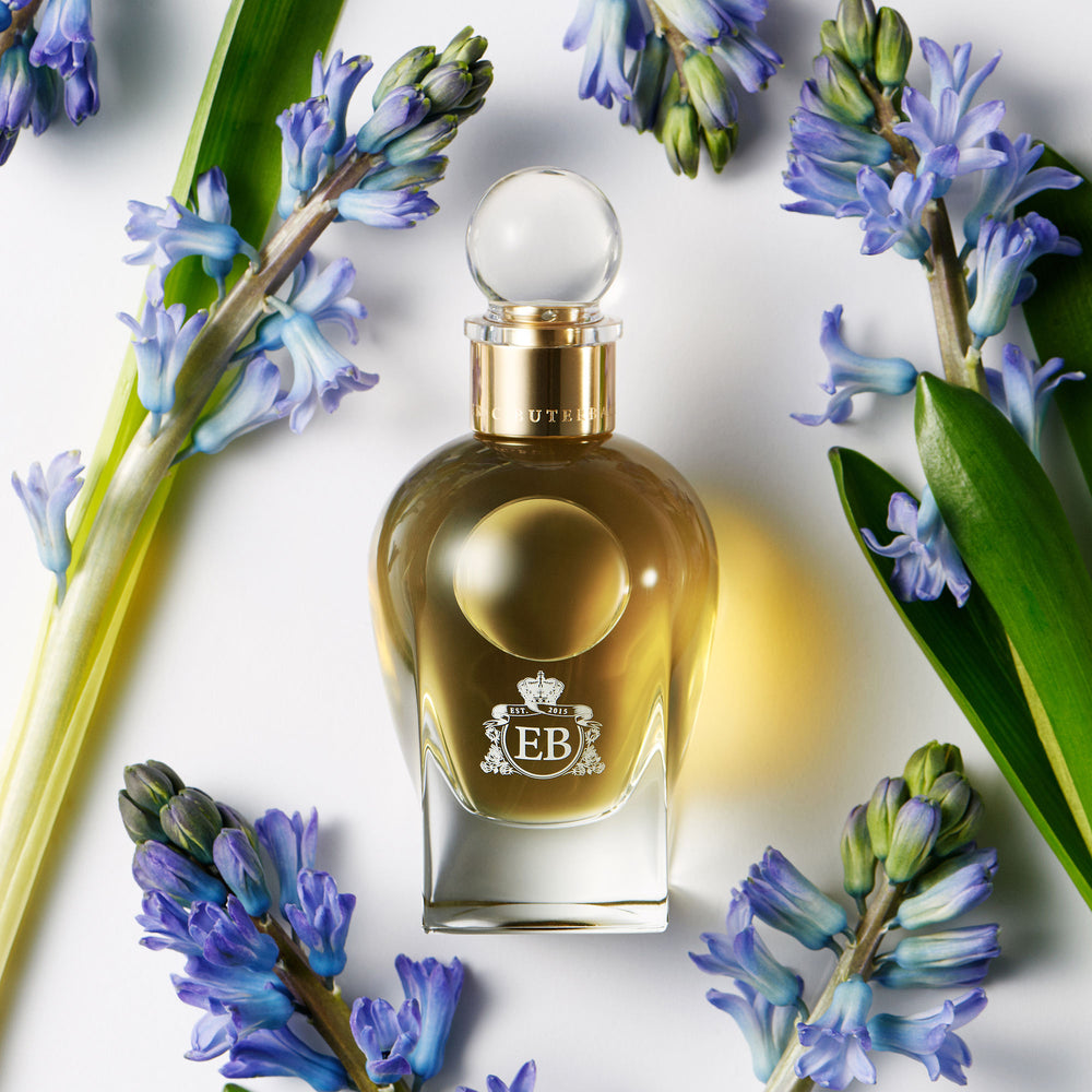 A 100 ml Apollo Hyacinth bottle lying next to some blue hyacinthus.