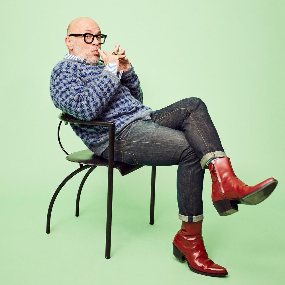 Eric Buterbaugh sitting on a chair on green background.