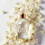 A 100 ml Kingston Osmanthus bottle lying on a bed of white osmanthus.