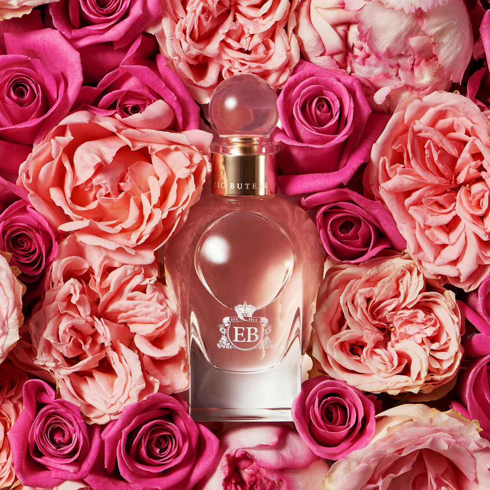 A 100 ml Sultry Rose bottle lying on a bed of pink roses.