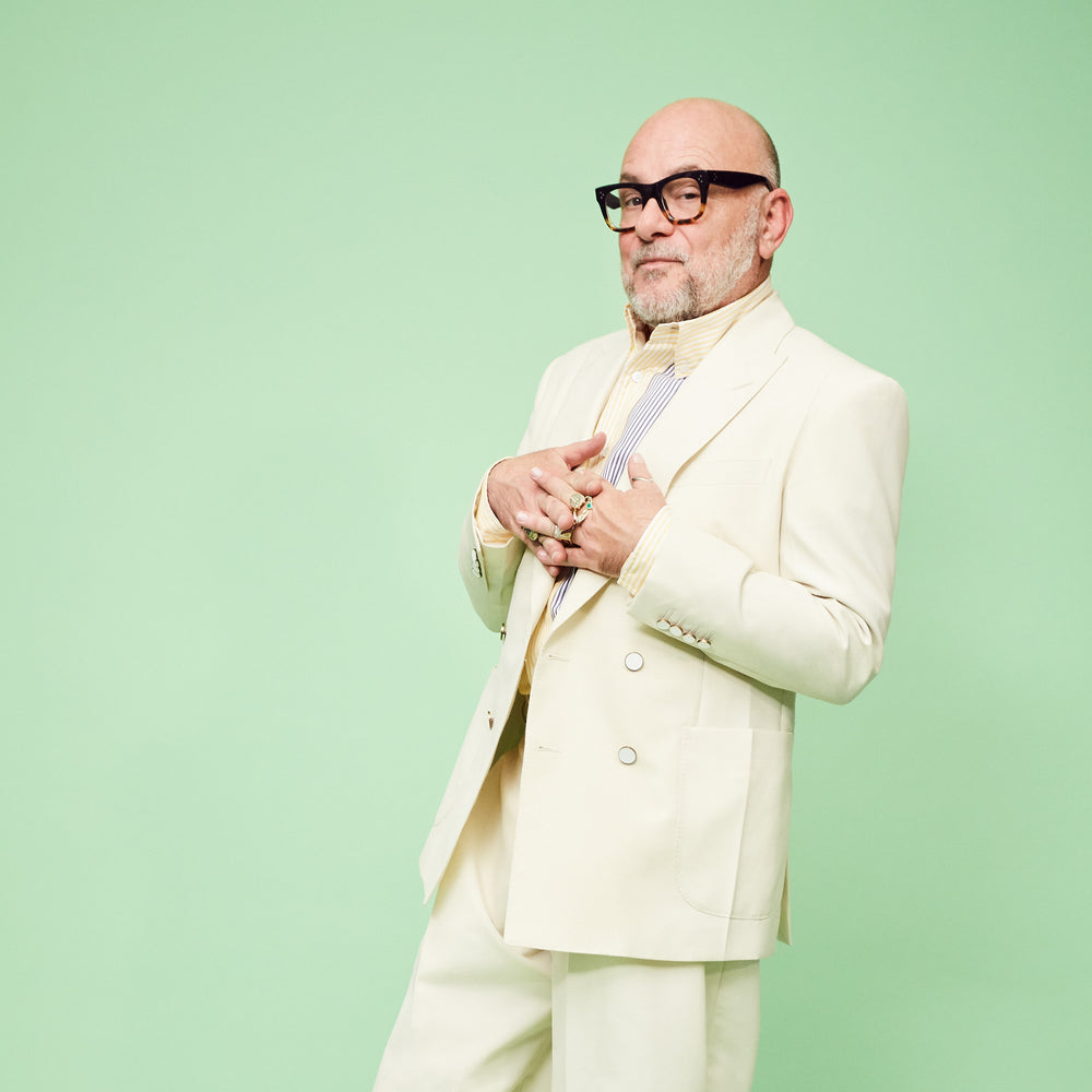 Eric Buterbaugh poses on green background with white suit.